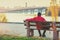 A single man tourist sitting on the bench on the embankment