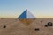 single metal prism pyramid cube hovering in the air in large empty desert environment abstract surreal concept 3D Illustration