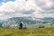 Single millenial man sits on a bench on a mountain plateau and looks at the mountains in front of him. Montenegro, Durmitor