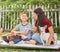 Single mom and sons play guitar together in the park