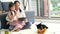 A single mother and daughter use a tablet in a living room with a puppy and a Shiba Inu father