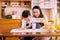 Single mother helping little daughter putting milk to glass with breakfast together at home kitchen in the morning