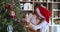 Single mother and little daughter trim fir tree with toys