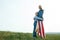 Single mother with son on independence day of USA. Woman and her child walk with the USA flag on the ocean coast