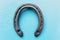 Single old rustic horse shoe on blue chalk painted wooden board