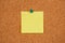Single one empty Yellow Post-it Sticky Note on a cork board with drawing pin