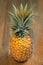 Single one full whole organic pineapple fruit on wooduprighten background