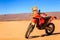 A single orange motorbike in the Sahara desert