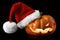 Single orange pumpkin Jack-o-lantern with Christmas Santa hat