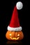 Single orange pumpkin Jack-o-lantern with Christmas Santa hat