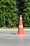 Single orange traffic cone on concrete street road