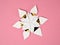 Single origami star snowflake in white and gold foil paper, on a pink paper background