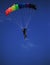 Single parachute jumper against blue sky background