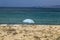 Single parasol at beach with turquoise ocean