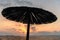 Single parasol umbrella at sunset