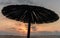 Single parasol umbrella at sunset