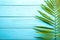 Single parlor palm leaf on blue wooden background