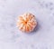 Single peeled tangerine at marble surface