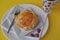 Single person breakfast of sweet pastry with fruit jam and a cup of hot tea on a colorful background