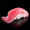 Single piece of tuna sushi nigiri on black background