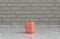 Single pink porcelain coffee mug on a front view kitchen counter top with gray tiled brick wall, 3d Rendering, close-up view