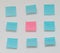Single pink post it note in sea of blue post it notes