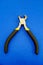 Single pliers tool with rubber handles for the master electrician on blue background