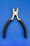 Single pliers tool with rubber handles for the master electrician on blue background