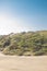 A single, powerful looking woman standing on top of a dune in the distance Kijkduin, The Hague, The Netherlands