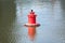 Single red buoy on quiet river closeup