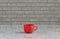 Single red color coffee mug on a front view kitchen counter top with gray tiled brick wall, 3d Rendering, close-up view