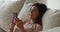 Single relaxed woman use smartphone while lying on sofa cushions