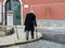 single senior man with cane walking on the cobblestone trottoir in central