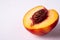 Single slice of peach nectarine fruit with seed on white background, copy space, angle view