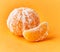 Single and slice peeled tangerine over yellow background