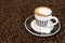 Single small coffee cup on coffee beans background