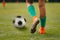 Single soccer football player standing next to ball ready to kick