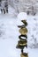 Single stack of snow covered round rocks in a peaceful snowy zen garden