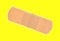 Single sticky bandage on yellow background