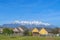 Single storey houses against striking snow capped mountain and vibrant blue sky