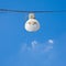 Single streetlight hanging from a metal cable on a blue background