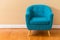 Single teal chair in an empty room