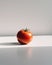 A single tomato sitting on a white surface. Generative AI image.