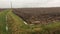 Single track road. Wet arable field. Mablethorpe Lincolnshire UK