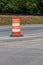 Single traffic barrel dividing an asphalt roadway, traffic safety creative copy space