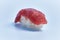 Single tuna nigiri sushi over blue background