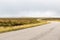 Single twisty, wavy, serpentine road with mist above in North Coast 500, Scotland