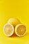 Single and two halves lemon fruit on a yellow background