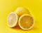 Single and two halves lemon fruit on a yellow background