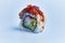 SIngle uramaki sushi over blue background